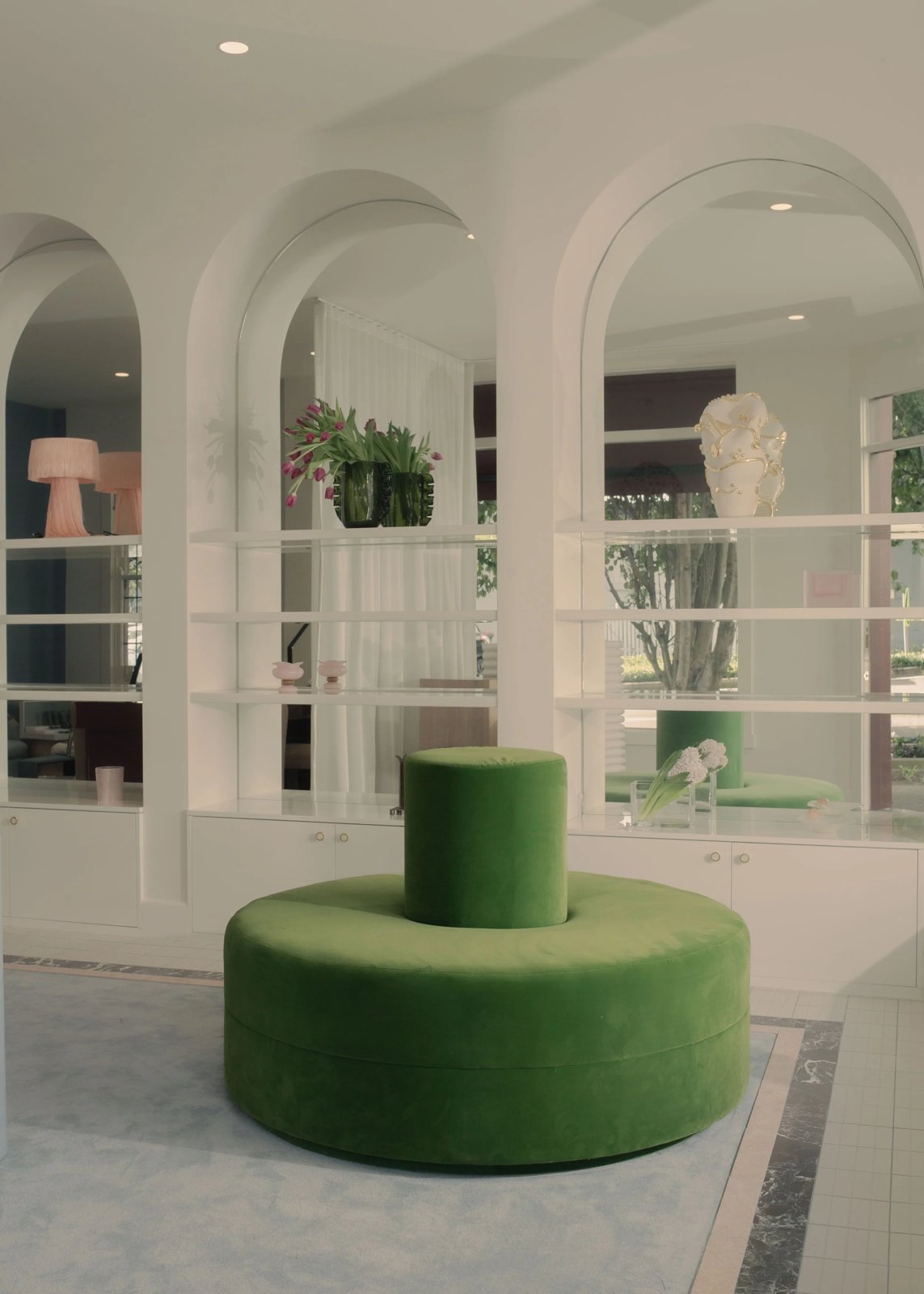 Arched retail lounge with a green velvet pouf at Rêve Skin + Beauty, Annandale