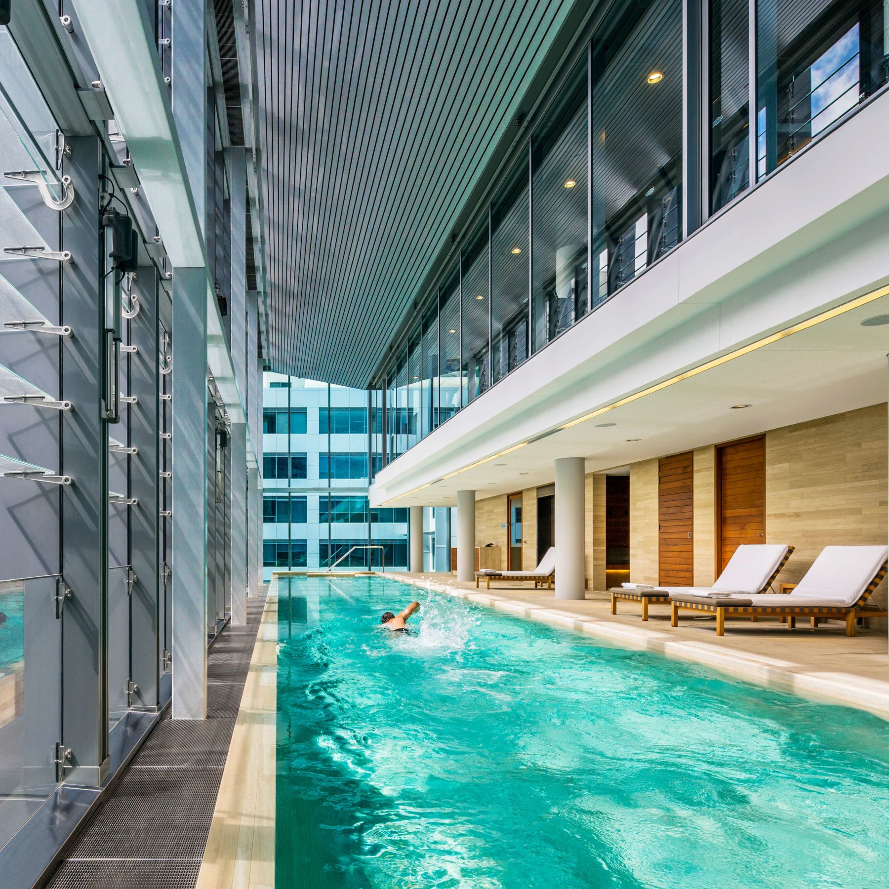 The 20-metre heated indoor lap pool at COMO Shambhala Urban Escape, flanked by sun loungers and heritage sandstone walls