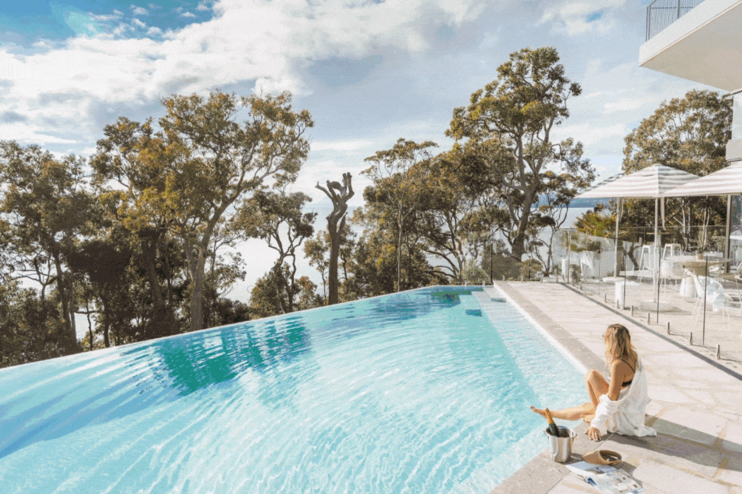 Coastal resort pool overlooking Soldiers Point at sunset, white modern architecture framed by ocean views