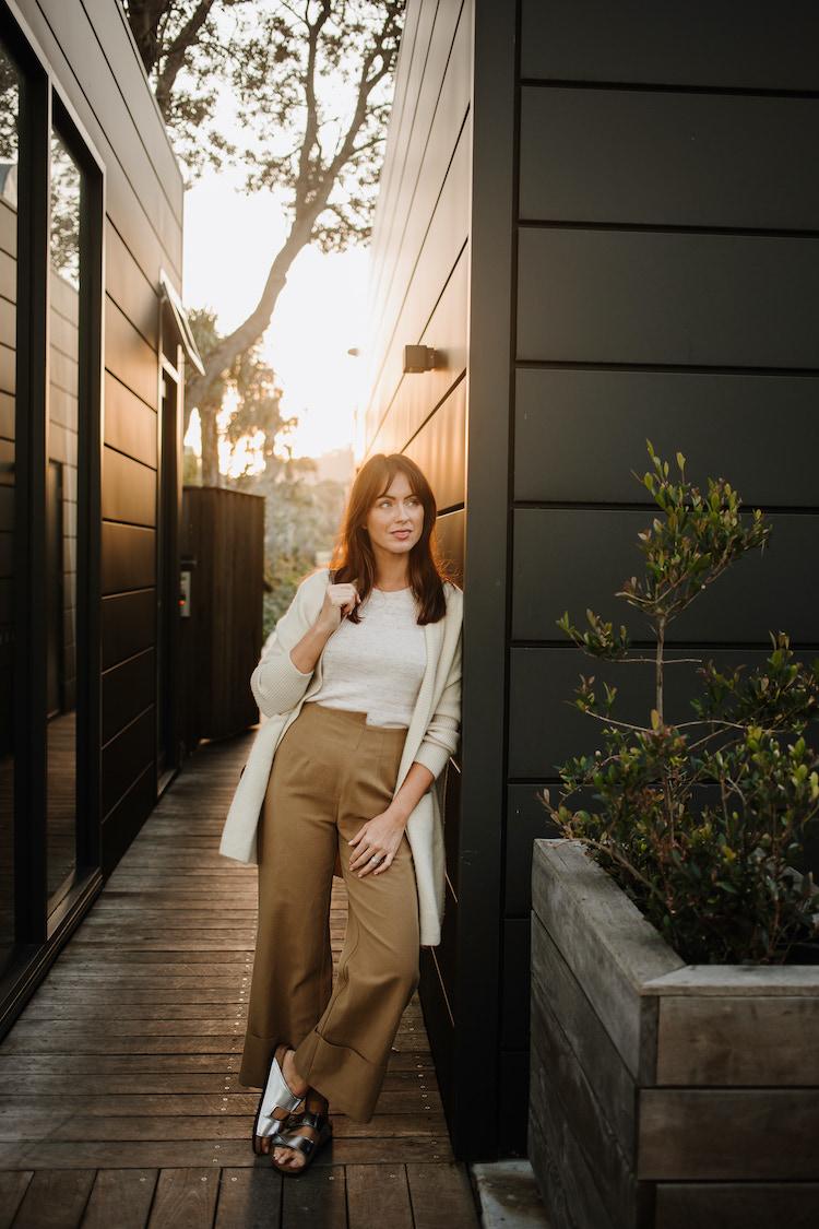 Sigourney wears Elka Collective knit, St Agni trousers, Mia Fratino cardigan, and Proenza Schouler x Birkenstock sandals
