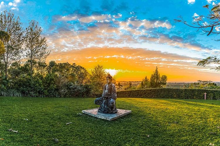 Morning at Gaia — a buddha watches the sunset over the hinterland