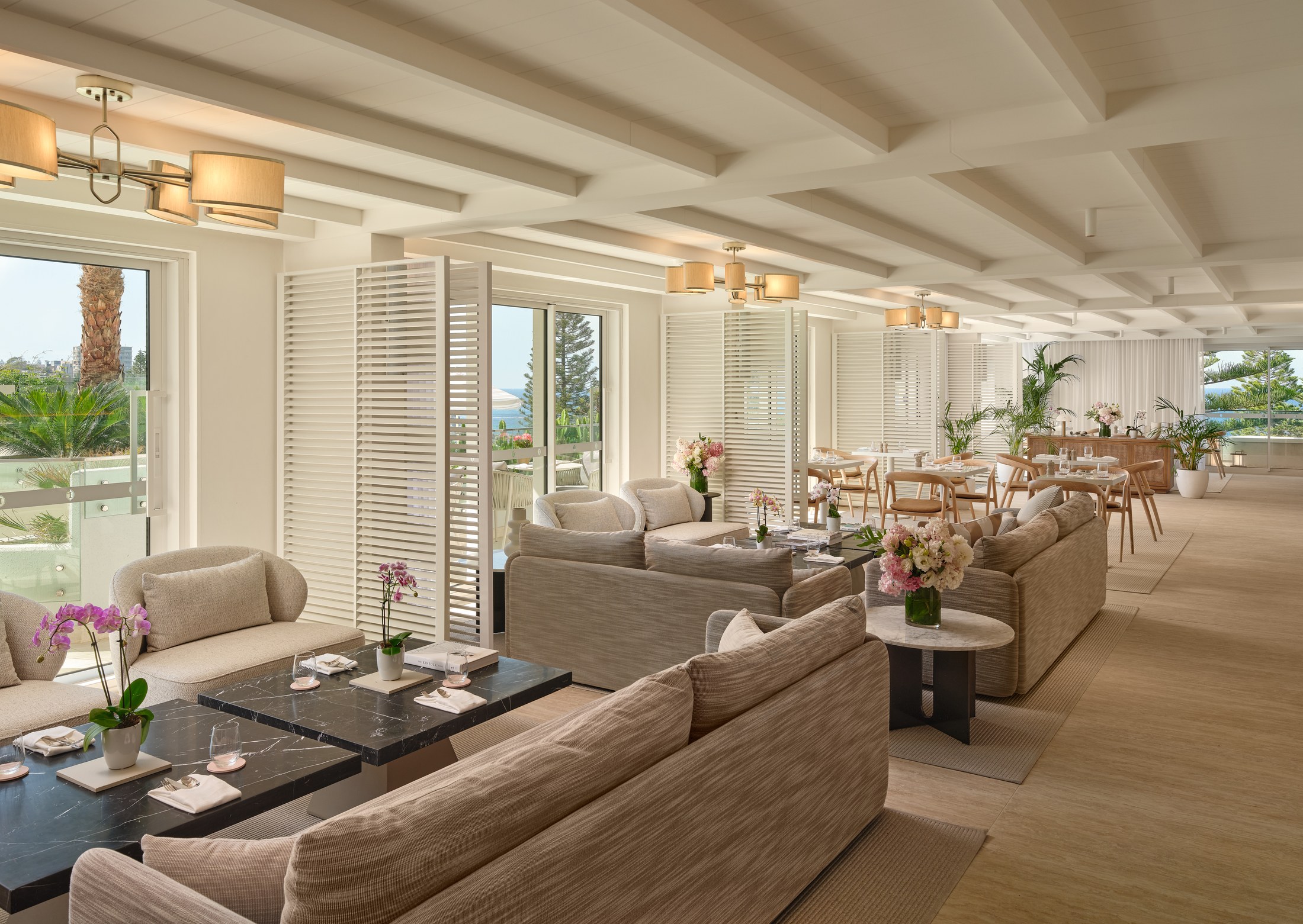 The Club InterContinental lounge at Coogee, white on white with linen curtains, potted orchids and geometric light fittings