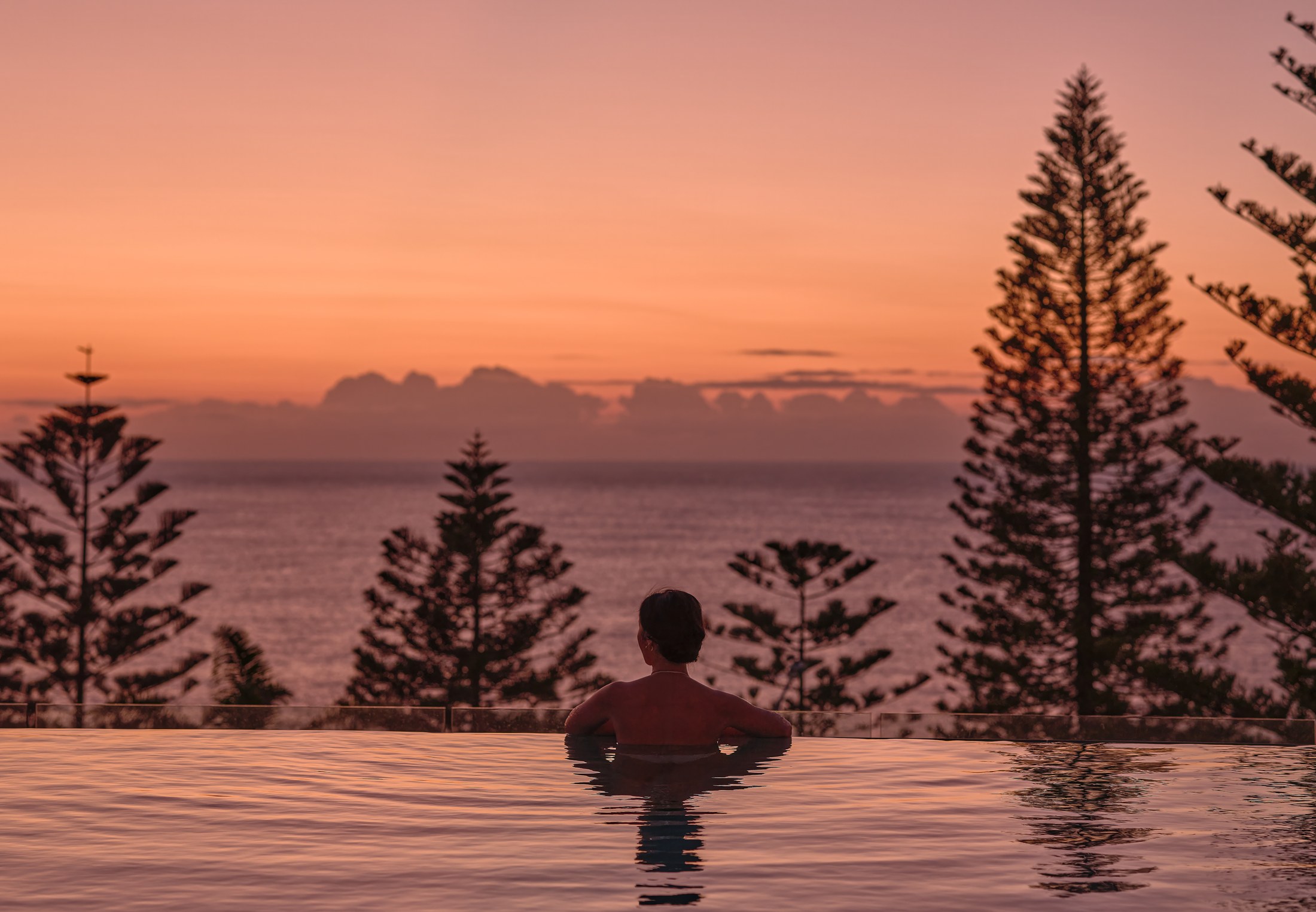 The oceanfront infinity pool at InterContinental Sydney Coogee Beach at sunset, the water going pink