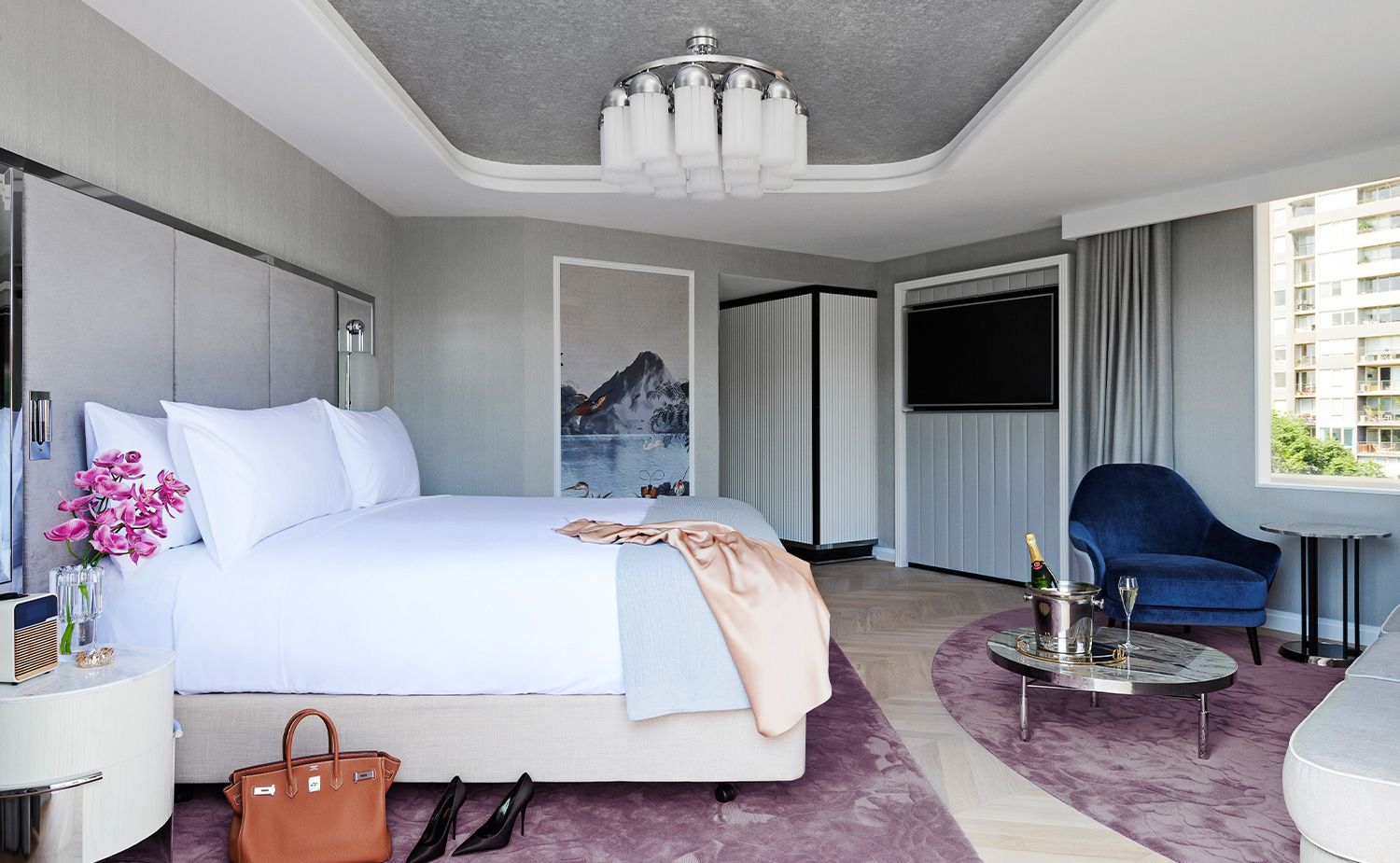 A twin room at The Royce Hotel Melbourne, monochrome furnishings, a champagne bucket and heels on the floor