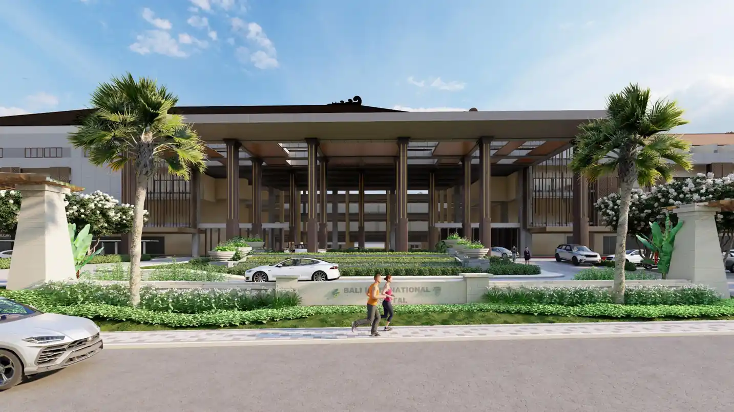 The modern glass-fronted exterior of Bali International Hospital, part of the Sanur Special Economic Zone
