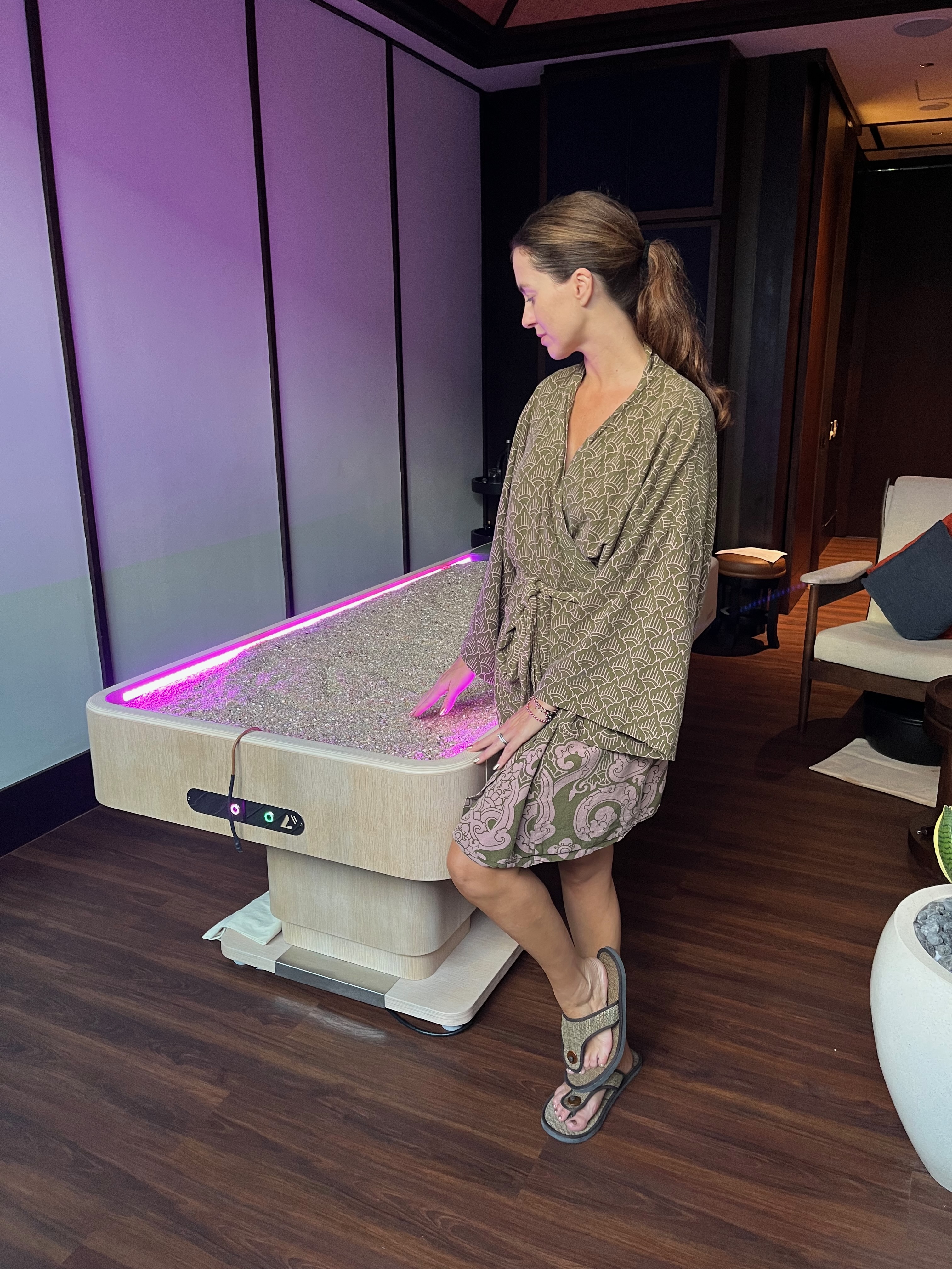 The crystal quartz treatment bed at Svasana Spa — a shallow tray filled with thousands of small polished crystals in warm tones