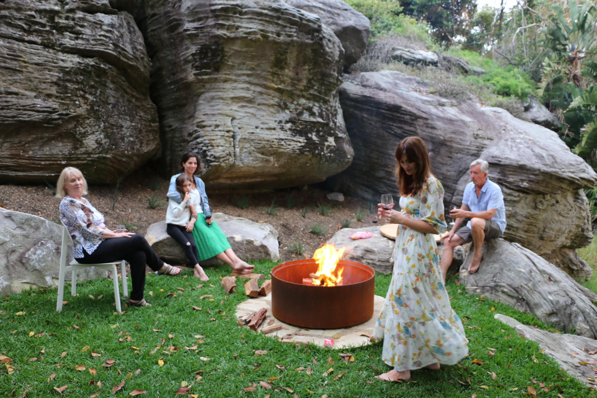 Fire pit with cathedral-stone surround at Crane Lodge, Wild Luxury, at dusk
