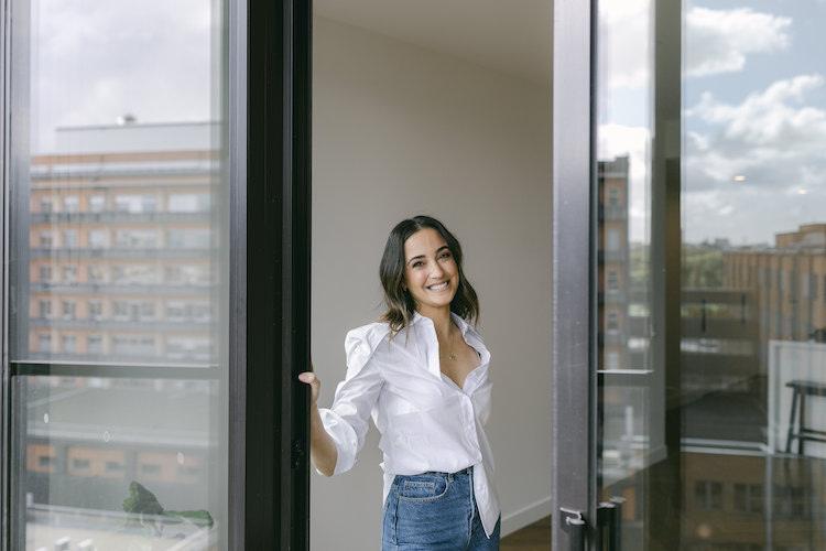 Abbey Gelmi stretching in athleisure against a sunlit glass door