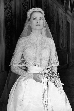 Grace Kelly on her wedding day in a lace-bodied gown with full skirt, veil and lily-of-the-valley bouquet