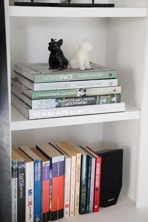 Bookshelf with Darren Palmer's design books and decorative figurines