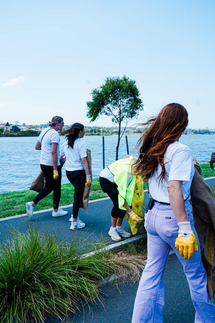Julia Stone with the weDo team outdoors in matching white TogetherWeDo t-shirts for Clean Up Australia Day