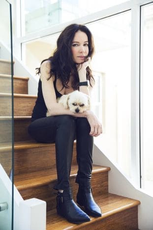 Rae Morris sitting on stairs with her dog Duffer, a Maltese cross