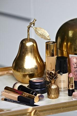 Beauty flat lay on a gold-rimmed marble tray with NARS, Giorgio Armani foundation and SkinCeuticals serum