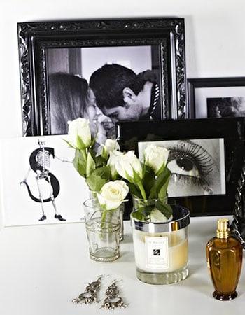 Framed photo gallery wall with black-and-white prints and a small gold decorative object