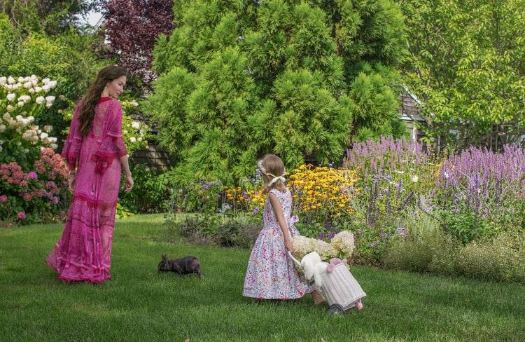 Vintage photo of teenage Olivia with mother Sylvie and father Olivier in a spring garden with magnolia