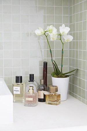 A Collection Of Roxy’S Favourite Scents And White Orchids Decorate Her Olive Coloured Bathroom