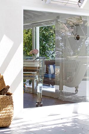 A Light-filled Living Room is Surrounded by an Outdoor Deck That Wraps Around the Home Accompanied by a Hanging Chair