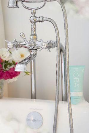 BEAUTIFUL FRENCH INSPIRED BATH TAPS, KORA ORGANICS ESSENTIAL BODY WASH AND FLOWERS CREATE A ROMANTIC BATHROOM RETREAT