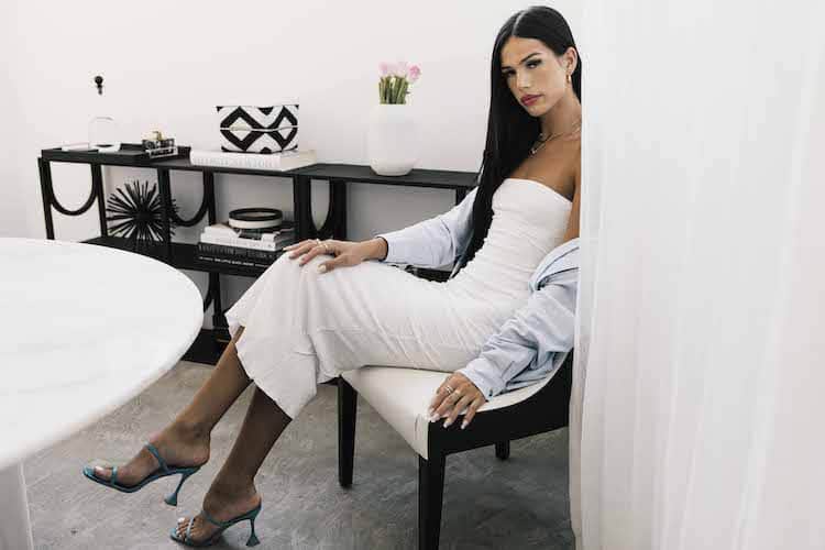 Riley Minford in white strapless midi dress and blue sandals