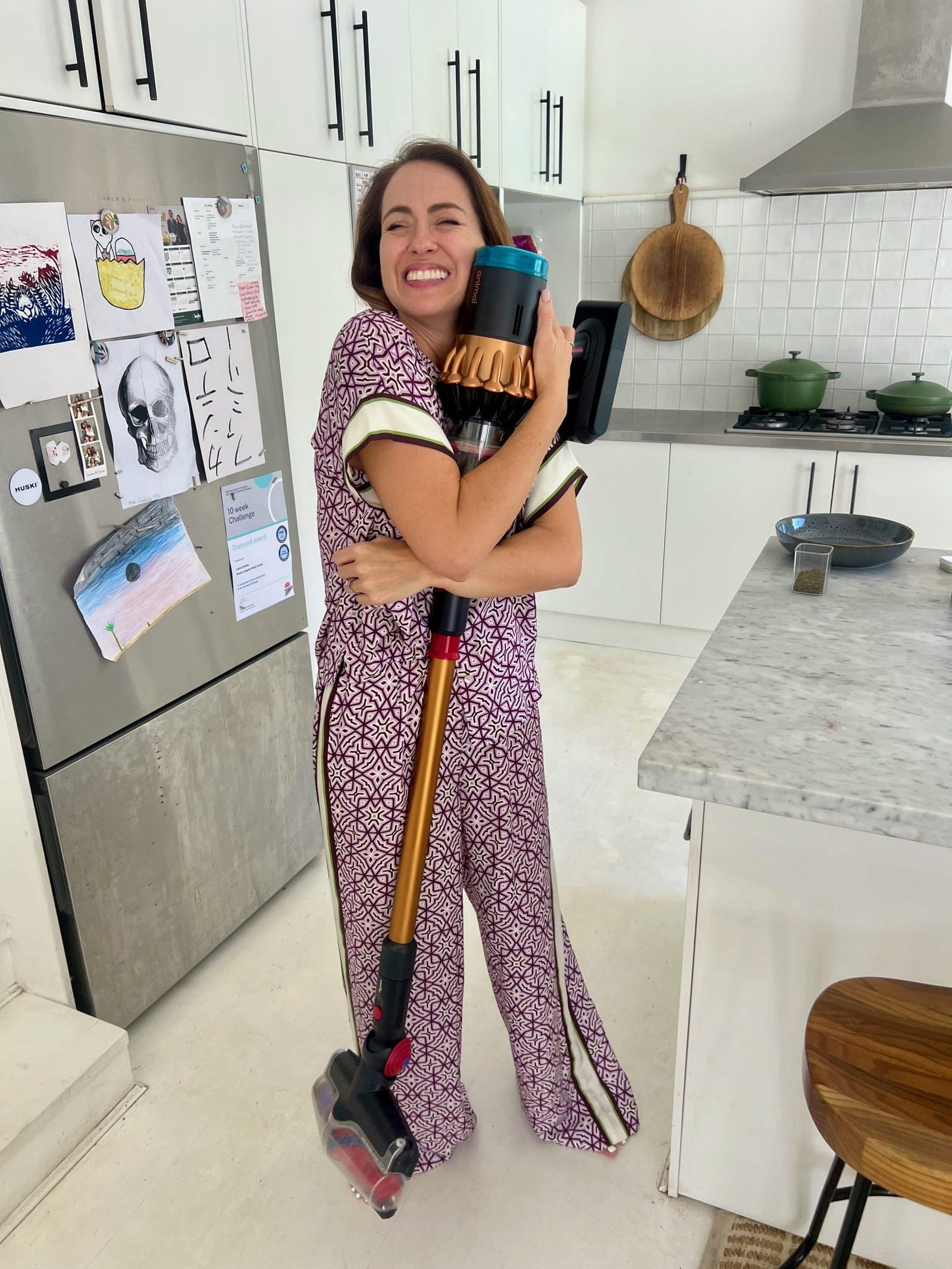 woman hugging Dyson vacuum at home