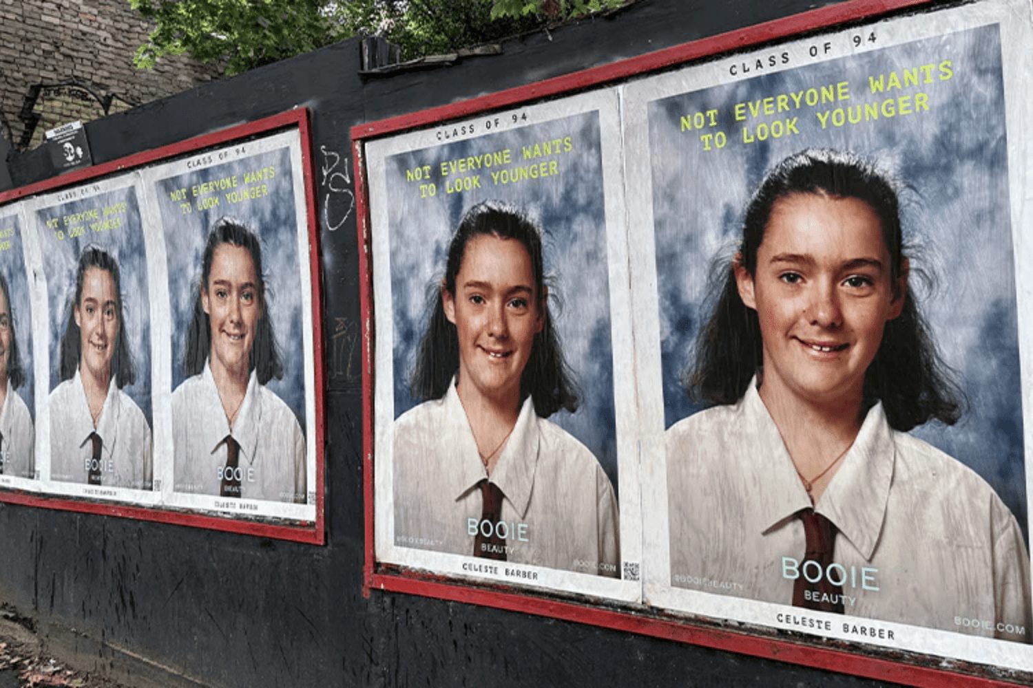 Celeste Barber's Booie 'Class of 94' school-portrait campaign posters pasted along a city wall