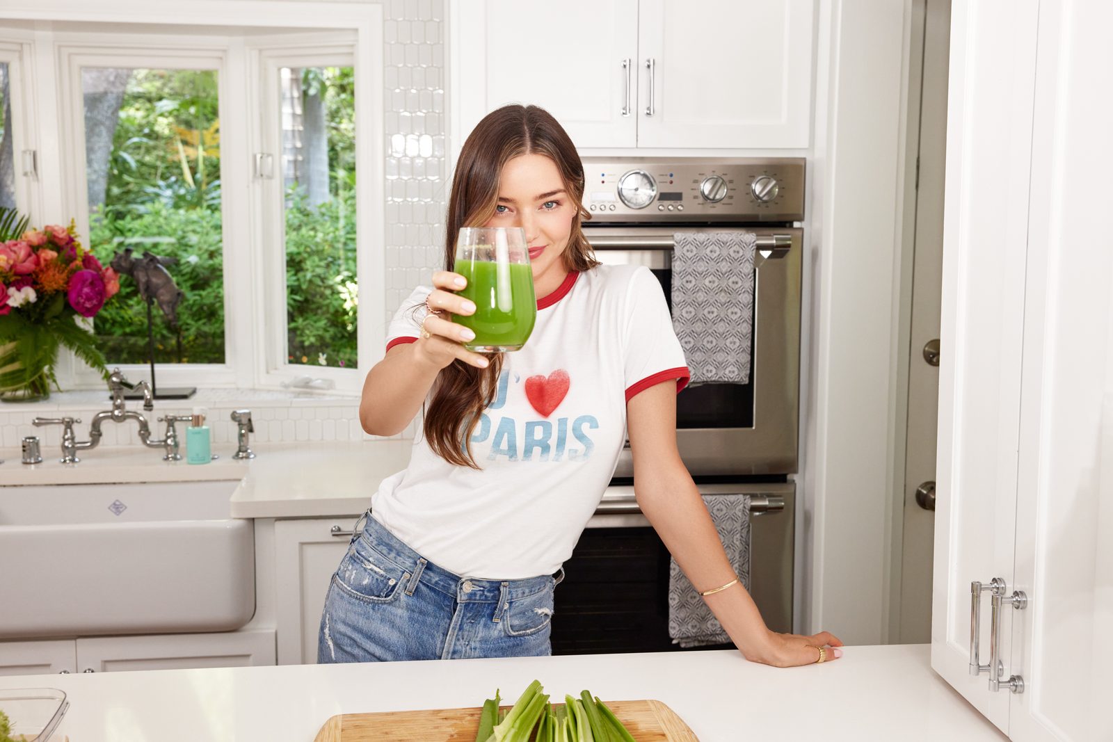 Miranda Kerr drinking a green juice in her kitchen