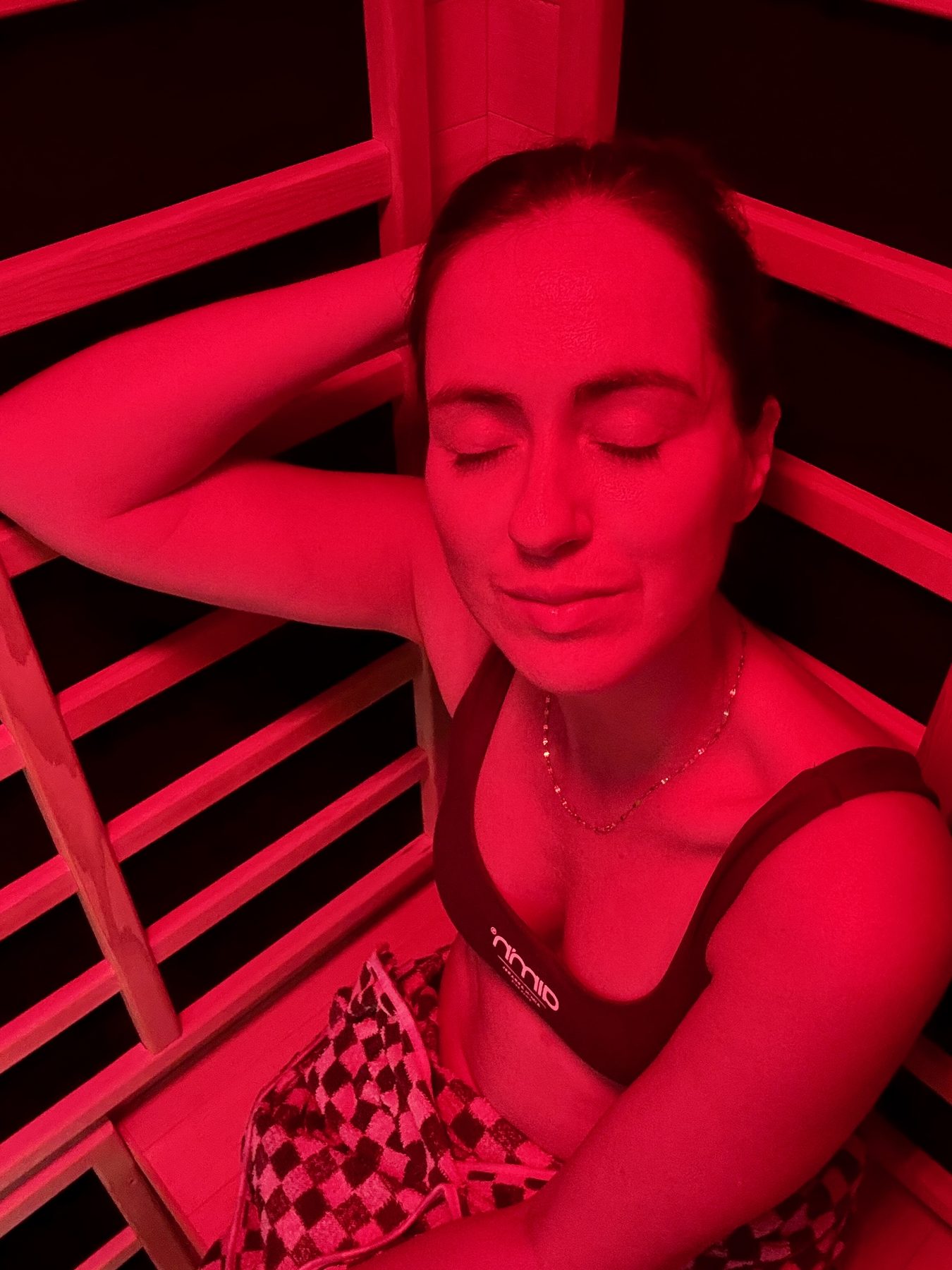 Sigourney Cantelo relaxing under the red NookAura colour light inside the Nook Elite