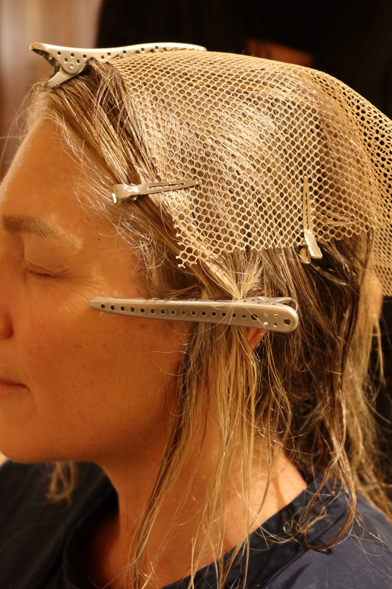 Side view of Colette's hair pinned beneath a mesh base, ready for integrated hair extensions