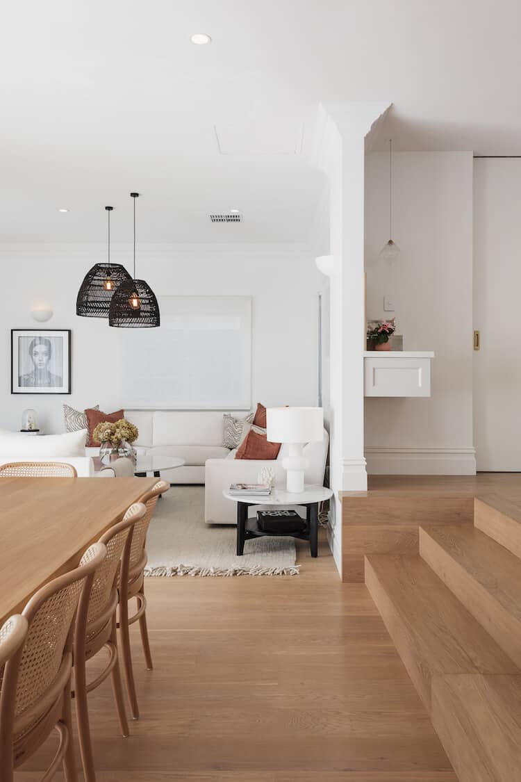 Clara's open-plan living and dining with white sofas, black rattan pendant lights and oak dining table