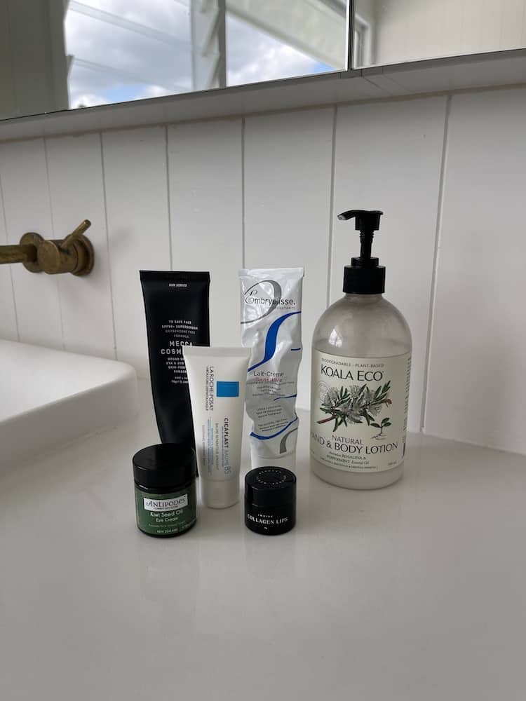 Skincare lineup on a bathroom ledge: Antipodes, La Roche-Posay, Embryolisse and Koala Eco body lotion