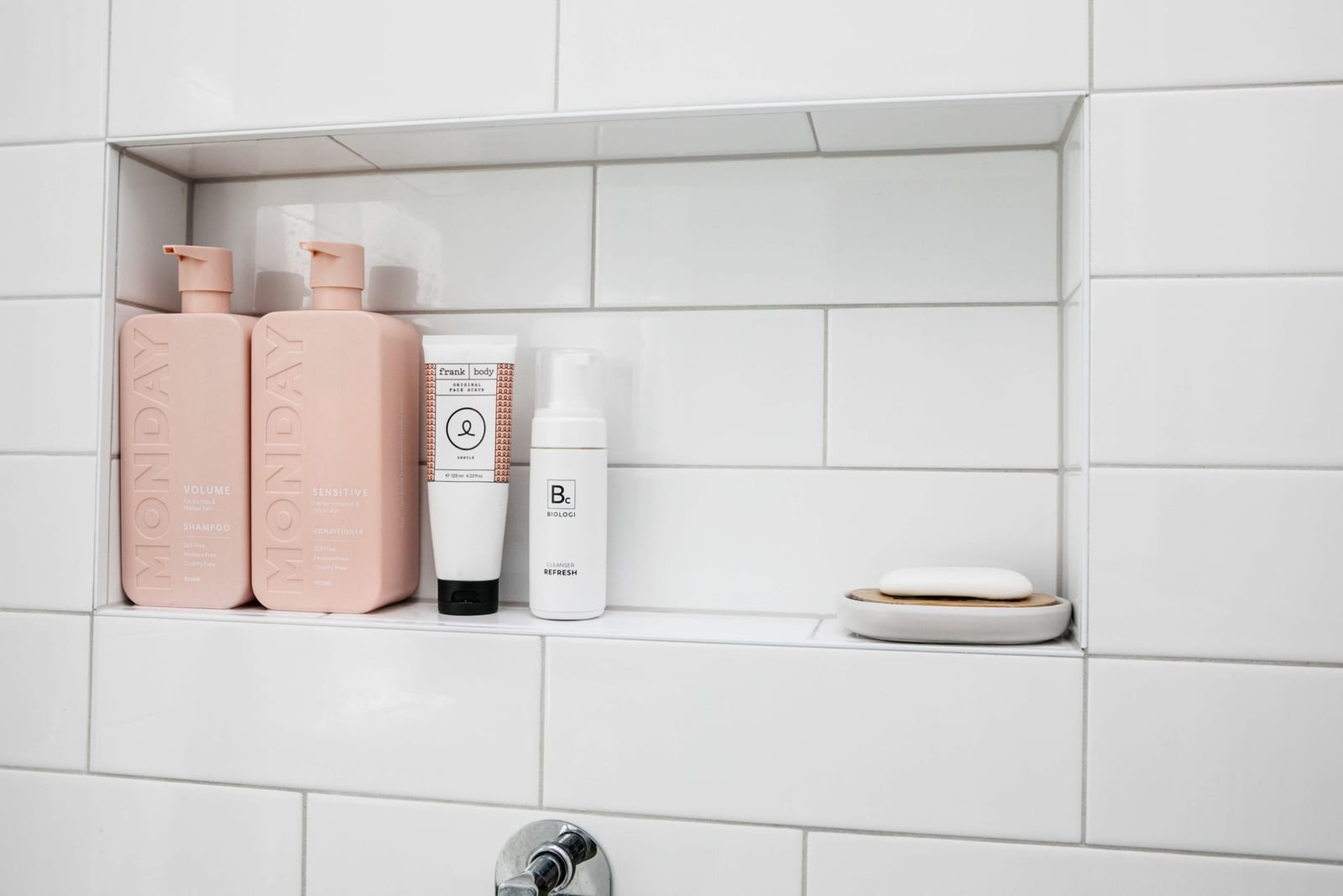Shower niche with Monday shampoo and conditioner, Frank Body scrub, Biologi cleanser and a soap dish