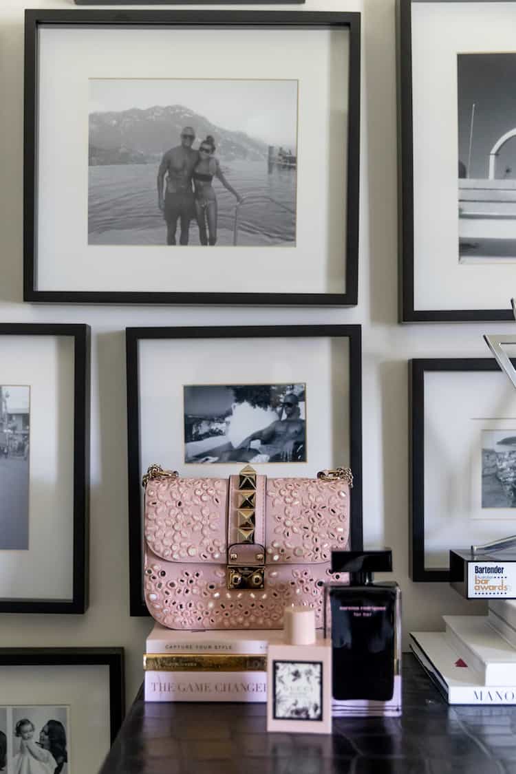 Pink Valentino Rockstud bag with Narciso Rodriguez perfume and black-and-white gallery wall above