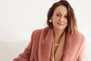 celeste lounging in blush coloured jacket and jewellery