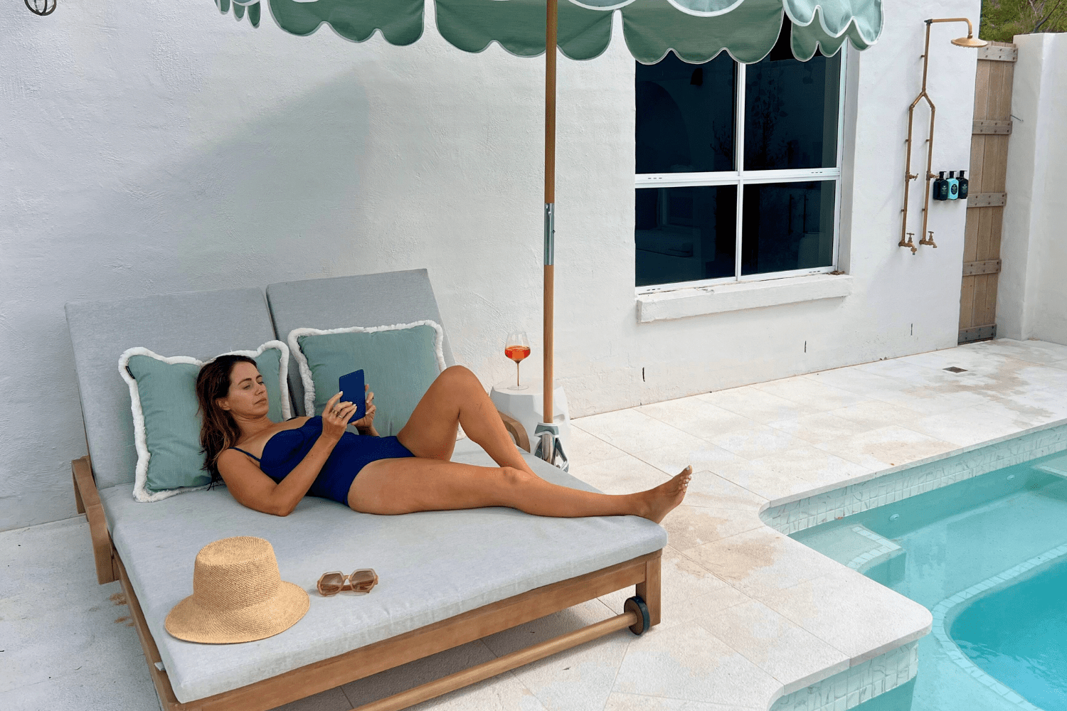 Sigourney Cantelo laying by the pool reading