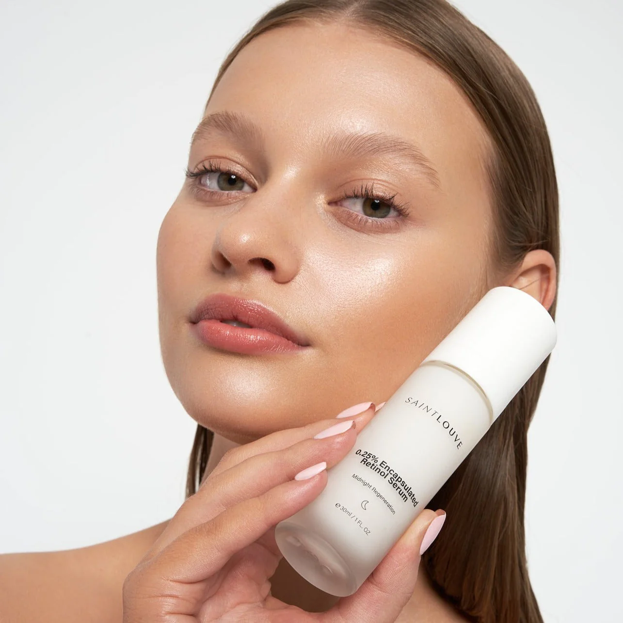Saint Louve serum bottle held by a girl beside her face