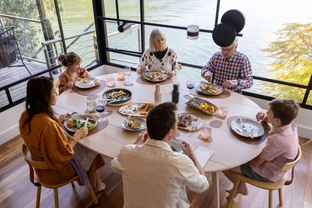 Family dining together overlooking the Hawkesbury River at Calabash Bay Lodge, Wild Luxury NSW