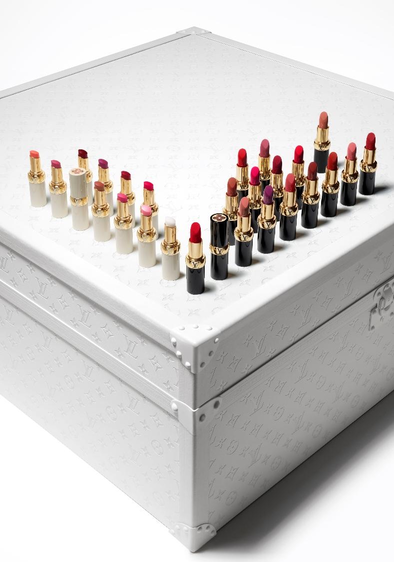 Louis Vuitton Rouge Lipstick and Louis Vuitton Baume displayed in a right angle on top of a white Louis Vuitton case.