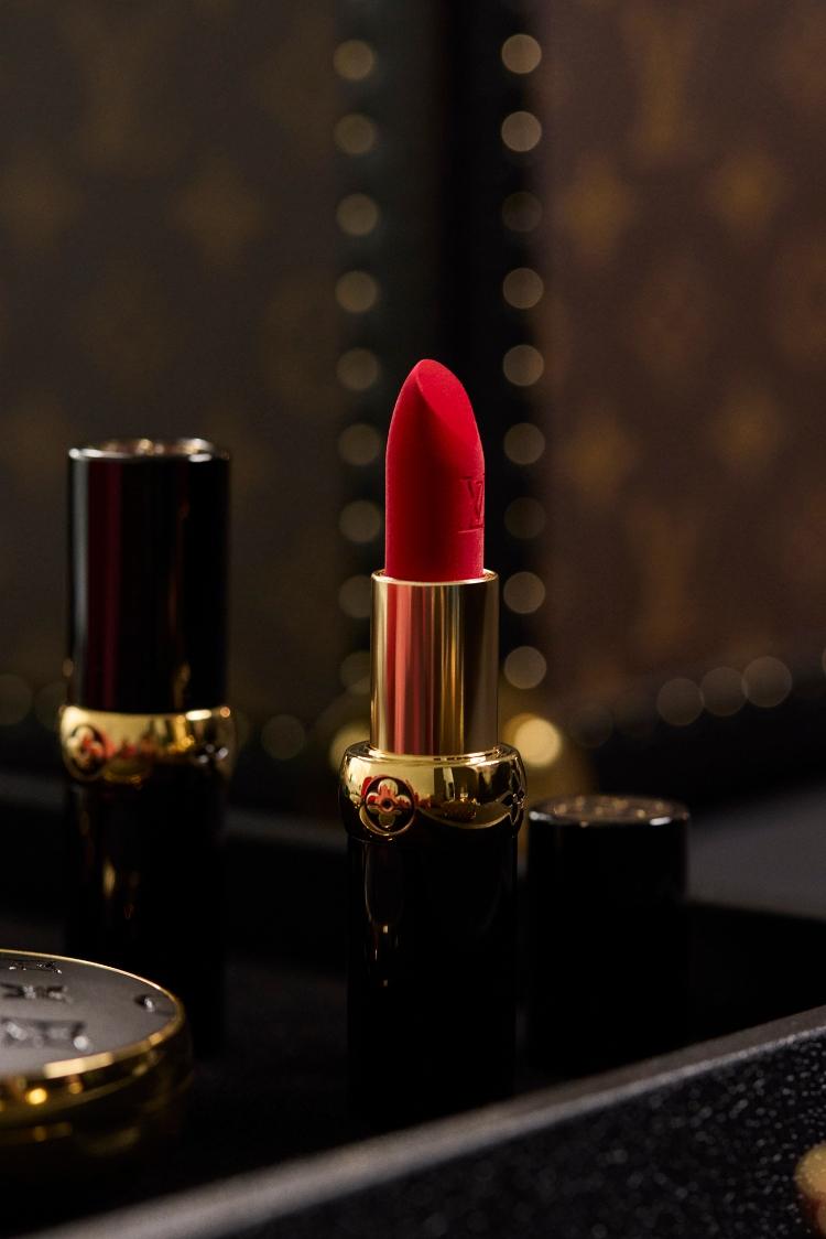 Red louis vuitton lipstick displayed against louis vuitton monogrammed valls
